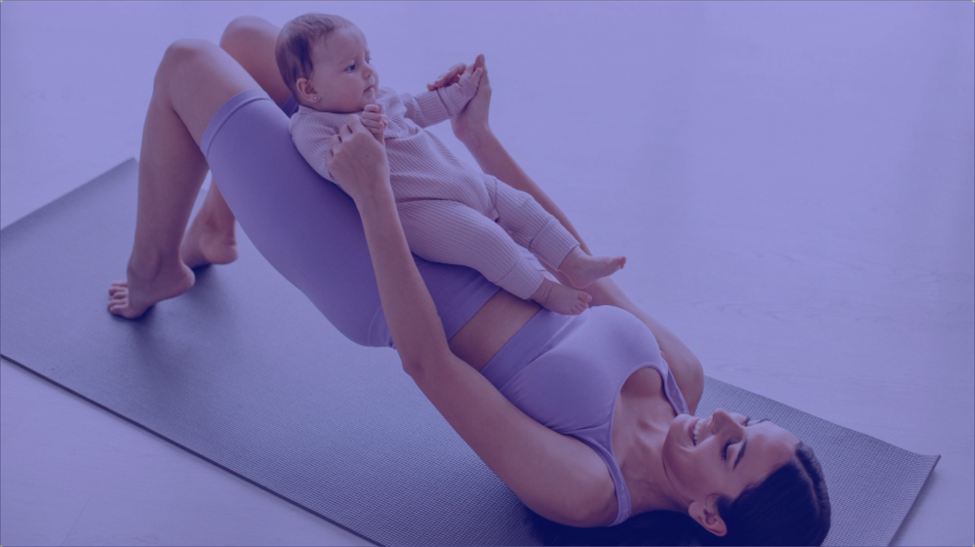 A mother practicing yoga with her baby on her lap.